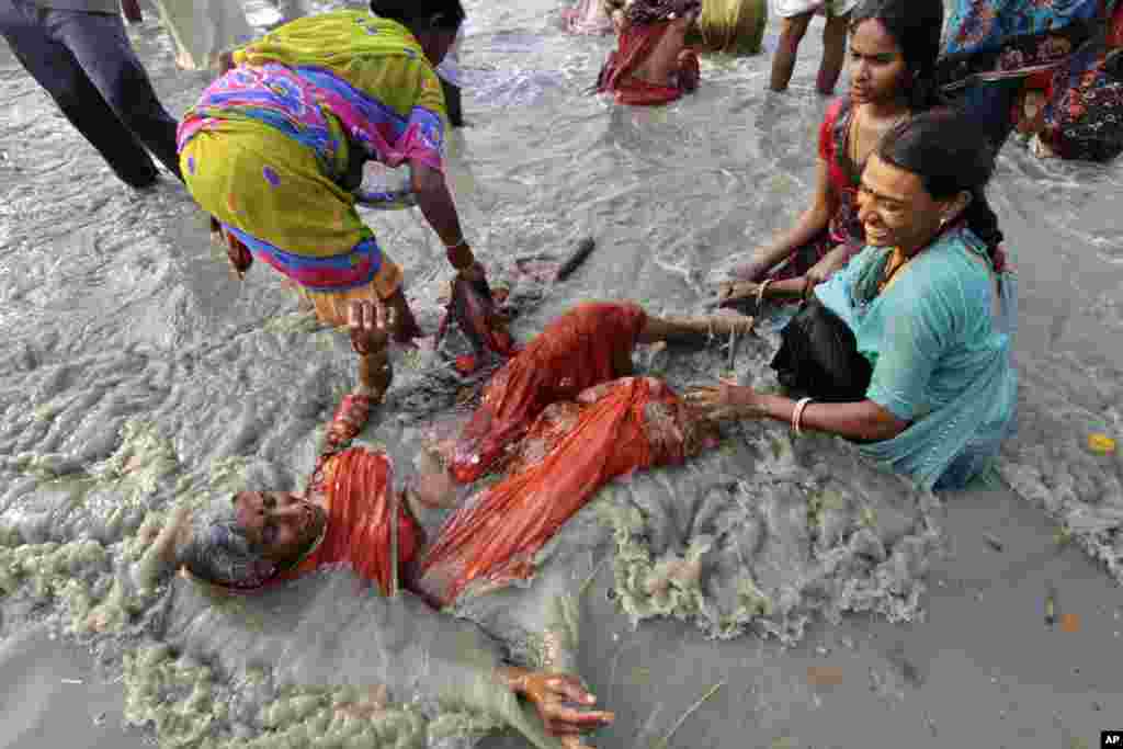 An elderly Hindu woman takes a holy dip at Gangasagar, India, January 14, 2013.