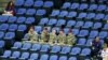 Soldiers sit in the empty seats held by the IOC as they watch the women's gymnastics qualification in the North Greenwich Arena during the London 2012 Olympic Games July 29, 2012.