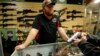 FILE - A gun store employee speaks to a customer about the purchase of a 9mm handgun in Bridgeton, Missouri, Nov. 13, 2014.
