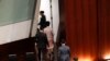 香港特首林郑月娥（从上至下第二人）在发表新一年度施政报告时受到民主派议员的抗议，林郑避席。（2019年10月16日）