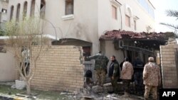 Libyan security forces inspect the site of a bomb explosion at the entrance of the residence of the Iranian ambassador in the capital Tripoli, Feb. 22, 2015.