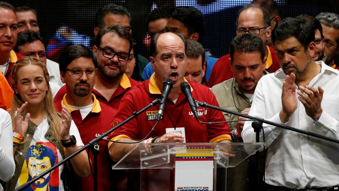 Venezuelan lawmaker and President of National Assembly, Julio Borges, center, speaks after the announcement of results of a symbolic referendum in Caracas, Venezuela, Sunday, July 16, 2017. Venezuelan's opposition said more than 7.1 million people responded to its call to vote Sunday in a symbolic rejection of President Nicolas Maduro's plan to rewrite the constitution, a proposal that has raised tensions in a nation suffering through widespread shortages and months of anti-government protests. (AP Photo/Ariana Cubillos)