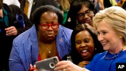 FILE - Democratic presidential candidate Hillary Clinton takes pictures with supporters after a campaign event at the Central Baptist Church in Columbia, South Carolina, Feb. 23, 2016.