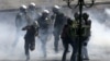 Riot police officers try to arrest a masked demonstrator during clashes in Athens, Greece, September 26, 2012. 