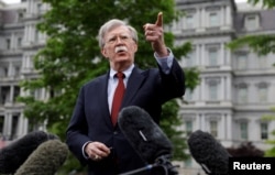 National security adviser John Bolton talks to reporters about Venezuela, outside the White House, May 1, 2019, in Washington.