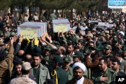 FILE - Civilians and armed forces members carry the flag-draped coffins of Iranian Revolutionary Guard's Gen. Mohsen Ghajarian, left, and some of his comrades who were killed in fighting in Syria, during their funeral ceremony in Tehran, Iran, Feb. 6, 2016.