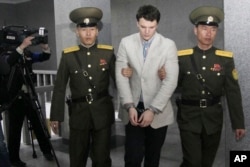 File-American student Otto Warmbier, center, is escorted at the Supreme Court in Pyongyang, North Korea, March 16, 2016. North Korea's highest court sentenced Warmbier to 15 years in prison after he allegedly attempted to steal a propaganda banner.