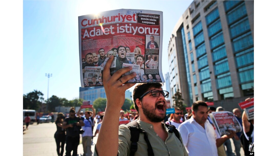 Activists, one holding a recent copy of the Cumhuriyet newspaper, march in Istanbul, July 24, 2017, protesting against a trial of journalists and staff from the newspaper, accused of aiding terror organizations.