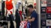 FILE - A man buys clothes from an American clothing store at a shopping mall in Beijing, China, July 15, 2019.