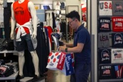 FILE - A man buys clothes from an American clothing store at a shopping mall in Beijing, China, July 15, 2019.