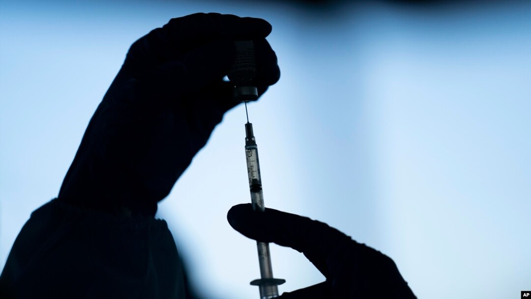 FILE - In this Jan. 21, 2021 file photo a medical staff member prepares the Pfizer COVID-19 vaccine at Tudor Ranch in Mecca, Calif.