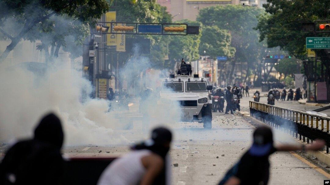 ARCHIVO - Manifestantes se enfrentan con la policía durante protestas contra los resultados electorales oficiales que declaran la reelección del presidente Nicolás Maduro, en Caracas, Venezuela, el 29 de julio de 2024.