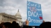 A woman holds up a sign outside the Capitol in support of the Deferred Action for Childhood Arrivals (DACA) program, Dec. 5, 2017, on Capitol Hill in Washington.
