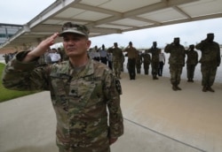 FILE - U.S. soldiers salute during a grand opening ceremony of the new headquarters building for the United Nations Command and US Forces Korea at Camp Humphreys in Pyeongtaek, June 29, 2018.