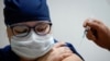 FILE - A medic at a regional hospital receives Russia's "Sputnik-V" vaccine shot against the COVID-19 disease in Tver, Russia, Oct. 12, 2020. 