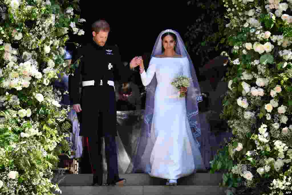 Britain's Prince Harry, Duke of Sussex and his wife Meghan, Duchess of Sussex, walk down the west steps of St George's Chapel, Windsor Castle, in Windsor, May 19, 2018, after their wedding ceremony.