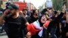 Iraqis grieve during the funeral procession of bomb victim, Akram Hadi, 24, who was killed in a massive truck bomb attack in the Karada neighborhood of Baghdad, Iraq, July 5, 2016. 