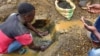 FILE - An artisanal miner washes tin ore before it is bagged up and weighed, ready to be transported to the nearest major town for export in the Kalimbi tin mine near the small town of Nyabibwe, DRC.