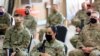 FILE - U.S. soldiers wearing protective masks are seen during a handover ceremony of Taji military base from US-led coalition troops to Iraqi security forces, in the base north of Baghdad, Iraq Aug. 23, 2020. 
