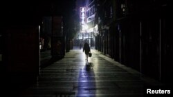 2020年2月1日，江西九江一女子走過一條寂靜的商業街。由新型冠狀病毒導致的武漢肺炎疫情仍在中國肆虐。 （路透社）