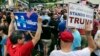 FILE - Supporters of Democratic presidential candidate Hillary Clinton and Republican presidential candidate Donald Trump hold signs at a Memorial Day parade in Chappaqua, N.Y., May 30, 2016.