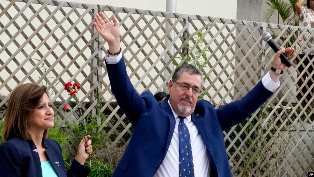 Bernardo Arévalo, candidato presidencial por el partido Movimiento Semilla, y la compañera de fórmula Karin Herrera saludan a sus seguidores fuera del edificio de la oficina del Fiscal General de Guatemala en la Ciudad de Guatemala, el 13 de julio de 2023.