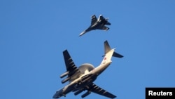 FILE - A Russian Air Force Beriev A-50 early-warning aircraft and a Sukhoi Su-27 jet fighter fly over Kaliningrad, Russia, April 25, 2020.