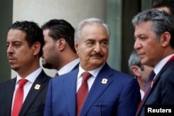 Khalifa Haftar, center, the military commander who dominates eastern Libya, leaves after an international conference on Libya at the Elysee Palace in Paris, May 29, 2018.