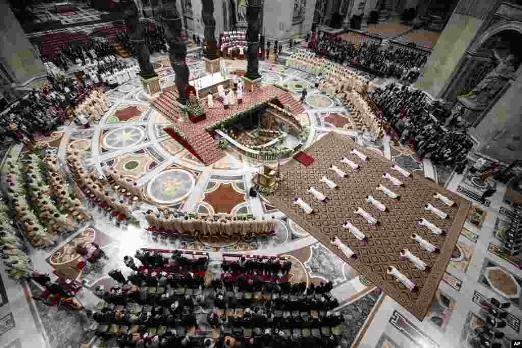 Priests lie face down on the floor during an ordination ceremony presided over by Pope Francis, in St. Peter's Basilica at the Vatican.