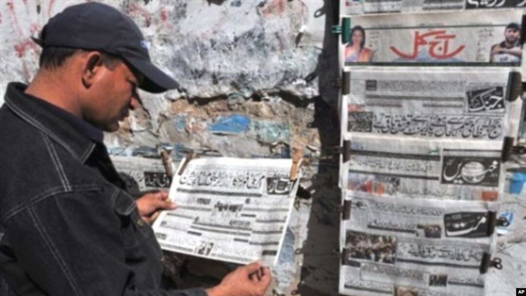 A Pakistani man reads an Urdu-language evening newspaper reporting the capture of a top Taliban commander at a news stand in Karachi, 16 Feb 2010