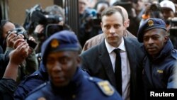 FILE PHOTO: FILE PHOTO: Oscar Pistorius is escorted by police officers as he arrives for his sententencing for the 2013 murder of his girlfriend Reeva Steenkamp, at North Gauteng High Court in Pretoria, South Africa