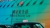 FILE - A taxi drives past a big banner featuring an advisory about China's new Hong Kong National Security Law, in Hong Kong, June 29, 2020.