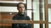 FILE - Wall Street Journal reporter Evan Gershkovich stands in a glass cage in a courtroom at the Moscow City Court in Moscow, Russia, on Dec. 14, 2023.