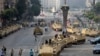 FILE - Egyptian army soldiers take their positions on top and next to their armored vehicles while guarding an entrance to Tahrir square, in Cairo, Egypt, Friday, Aug. 16, 2013. 