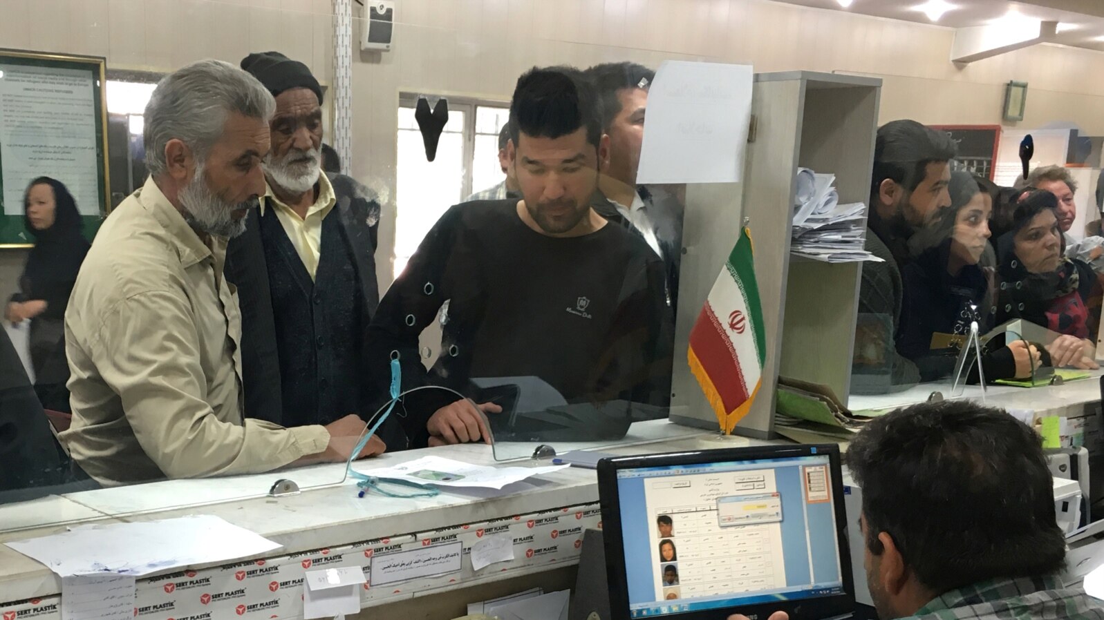 FILE - Afghan refugees submit documents at a refugee center in Tehran, Iran, Oct. 24, 2016. UNHCR estimates that 3 million Afghans are living in Iran.