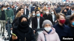 People wearing protective masks walk along the principal shopping street of Via del Corso, amidst the coronavirus disease (COVID-19) outbreak, in Rome, Italy, February 27, 2021. 