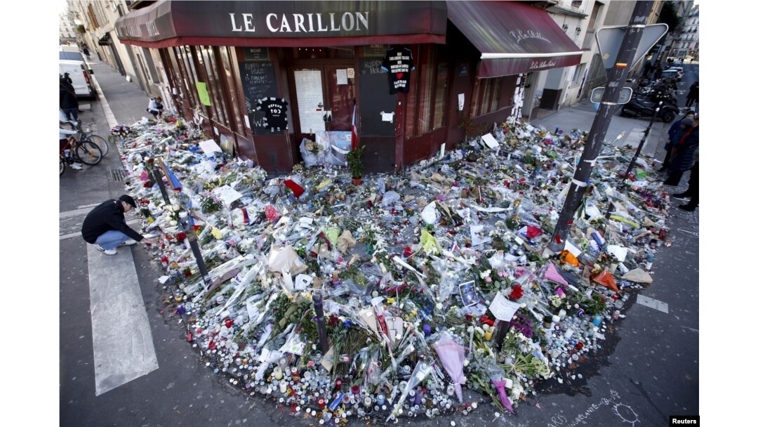 People mourn outside "Le Carillon" restaurant a week after a series of deadly attacks in Paris, Nov. 22, 2015.