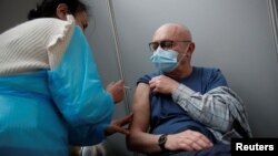 An elderly visitor receives a dose of the Pfizer-BioNTech COVID-19 vaccine at the Cent Quatre cultural center in Paris, France, Feb. 1, 2021. 