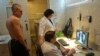 A man (L) is x-rayed to detect tuberculosis during a medical examination, organized by the Belarusian Red Cross society, in Minsk, Jan. 29, 2013.