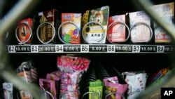 FILE - Condoms are seen above chewing gum and food snacks in a vending machine in China, Sept. 23, 2007. State law limits what Yale University in Connecticut can dispense in its campus vending machines.
