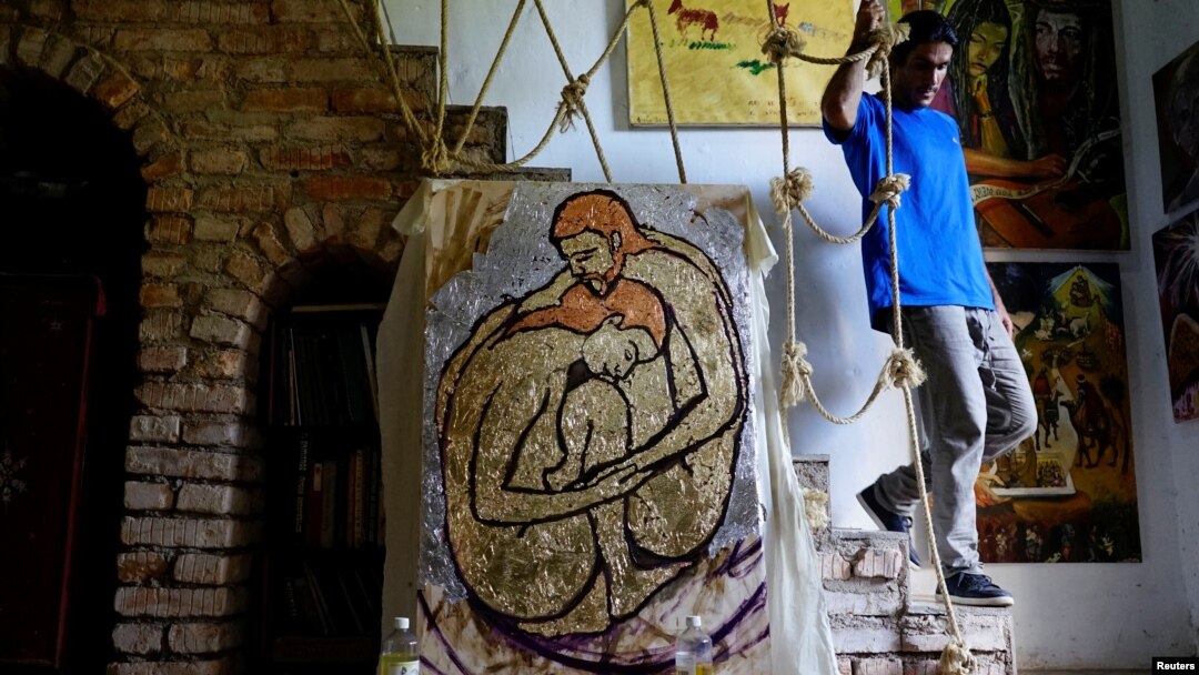 Cuban artist Italo Esposito, a participant of the "00Biennial", walks in his home next to his work in Havana, Cuba, May 2, 2018. 