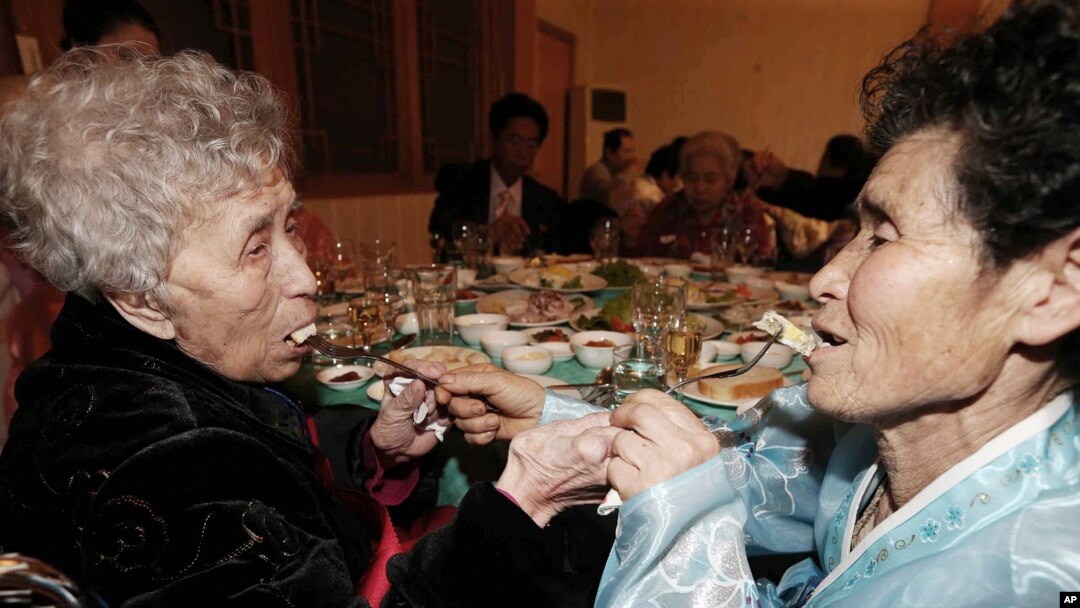 20일 금강산에서 열린 남북 이산가족 상봉 행사장에서 한국의 이영실 씨(87)가 북한에 살고 있는 딸 동명숙 씨(66)와 만나 서로에게 음식을 먹여주고 있다.