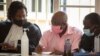 Paul Rusesabagina, center, whose story inspired the film "Hotel Rwanda", wears a pink prison uniform as he appears for a bail hearing at a court in the capital Kigali, Rwanda, Sept. 25, 2020. 