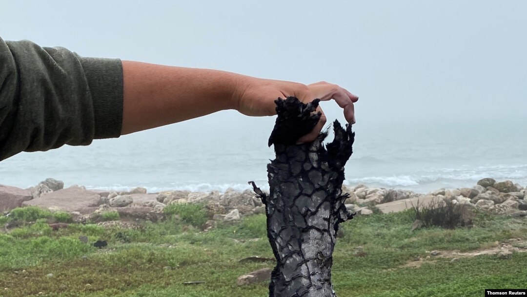 A spectator holds a piece of debris which was blown 5 miles from the site where SpaceX test rocket SN11 exploded upon landing, in Boca Chica, March 30, 2021.