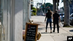 Un cartel anuncia el número de clientes permitidos en una tienda de West Hollywood, en el área de Los Ángeles, California, el 18 de noviembre de 2020.