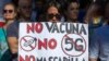 FILE - Demonstrators attend a protest against nationwide restrictions against COVID-19 in Madrid, Spain, Aug. 16, 2020. A banner reads in Spanish 'No vaccine No 5G No mask'.