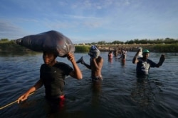 美國邊境巡邏人員騎馬阻止海地移民從格蘭德河的墨西哥一側淌水進入美國邊境城市德爾里奧。（2021年9月19日）