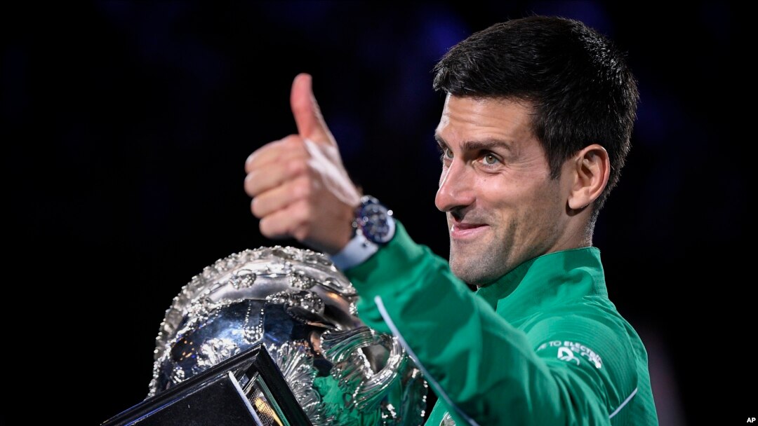 Serbia's Novak Djokovic gestures as he holds the Norman Brookes Challenge Cup after defeating Austria's Dominic Thiem in the final of the Australian Open tennis championship in Melbourne, Australia, Monday, Feb. 3, 2020. (AP Photo/Andy Brownbill)