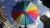 A person holds an umbrella with colored condoms in London, September 18, 2010