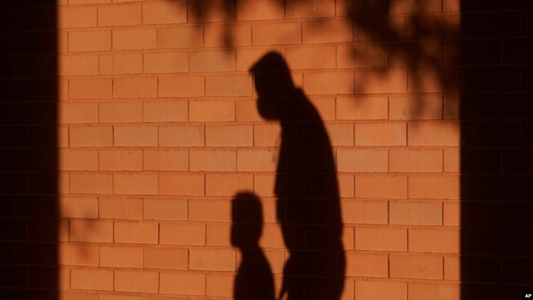 FILE - The shadows of a man and child are cast on a wall in Davie, Florida, Oct. 9, 2020. Poverty in the United States surged in 2022, particularly among children, after social support programs put in place during the coronavirus pandemic expired, according Census Bureau data. 
